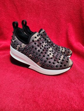 Gianni Bini Pellow camouflage studded slip-on wedge sneakers.